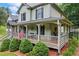 Charming front porch features outdoor seating, perfect for relaxing and enjoying the serene surroundings of this beautiful home at 1301 Ficklen Church Way, Canton, GA 30114