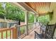 Covered porch overlooking a wooded area featuring rocking chairs and decorative plantings at 1301 Ficklen Church Way, Canton, GA 30114