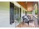 Cozy front porch features wicker seating, perfect for enjoying the serene views and relaxing in the shade of this charming home at 1301 Ficklen Church Way, Canton, GA 30114