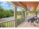 Inviting covered porch with seating and wooden ceiling overlooks a wooded area and the neighborhood at 1301 Ficklen Church Way, Canton, GA 30114