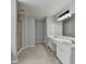Bright bathroom featuring double vanities with white cabinets, tile flooring, and a glass door shower at 3805 Roxwood Park Dr, Buford, GA 30518
