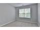 Bright bedroom featuring plush carpet, a large window, and neutral walls at 3805 Roxwood Park Dr, Buford, GA 30518