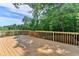 View of the wooden deck under a blue sky, surrounded by lush trees at 3805 Roxwood Park Dr, Buford, GA 30518