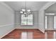 Dining room with gleaming hardwood floors, natural light, and elegant chandelier lighting at 3805 Roxwood Park Dr, Buford, GA 30518