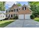 Attractive two-story brick home featuring a well-maintained lawn and a two-car garage at 3805 Roxwood Park Dr, Buford, GA 30518