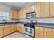 Kitchen featuring wood cabinets, stainless steel appliances, and granite countertops at 3805 Roxwood Park Dr, Buford, GA 30518