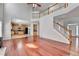 Open living room featuring a fireplace, hardwood floors, and view of the kitchen and upstairs at 3805 Roxwood Park Dr, Buford, GA 30518