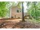 The side of this home features a backyard with a wooden deck and lots of mature trees at 459 Bakers Bridge Cir, Douglasville, GA 30134