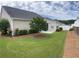 Well-maintained backyard with lush green lawn, neat landscaping, and a retaining wall at 802 Village Pl, Loganville, GA 30052