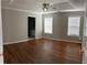 Spacious bedroom with hardwood floors, a ceiling fan, and natural light from two windows at 802 Village Pl, Loganville, GA 30052