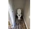 Modern half bathroom featuring a toilet and sleek, dark wood-look flooring at 125 Toccoa Rd, Carrollton, GA 30116