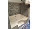 Relaxing bathtub featuring a tiled surround and handheld shower fixture at 125 Toccoa Rd, Carrollton, GA 30116