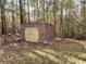 Exterior of the storage shed with double doors in the wooded backyard at 125 Toccoa Rd, Carrollton, GA 30116