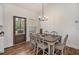 Cozy dining area featuring a modern chandelier, wood floors, and a back door with outdoor view at 461 Barnwood Dr, Rockmart, GA 30153
