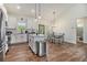 Bright kitchen boasts white cabinetry, granite counters, stainless steel appliances, and a center island with pendant lighting at 461 Barnwood Dr, Rockmart, GA 30153