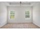 Bright bedroom showcasing carpet, natural light through two windows, and a ceiling fan at 461 Barnwood Dr, Rockmart, GA 30153