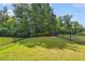 Serene backyard with lush green lawn, mature trees, and secure black metal fencing at 502 Abbington River Ln, Atlanta, GA 30339