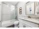Modern bathroom with a tub-shower combo, glass enclosure, and a vanity with granite countertop at 502 Abbington River Ln, Atlanta, GA 30339