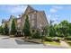 Brick townhome featuring a two-car garage with mature trees at 502 Abbington River Ln, Atlanta, GA 30339