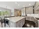 Bright kitchen with grey cabinets, an oversized island, stainless appliances, and dark hardwood flooring at 502 Abbington River Ln, Atlanta, GA 30339