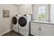 Well-lit laundry room featuring modern washer/dryer units and ample storage cabinetry at 502 Abbington River Ln, Atlanta, GA 30339