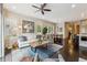 Open-concept living room with a ceiling fan, lots of windows and hardwood flooring at 502 Abbington River Ln, Atlanta, GA 30339