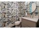 Stylish powder room featuring patterned wallpaper, a round mirror, and under sink storage at 502 Abbington River Ln, Atlanta, GA 30339