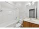 Full bathroom with white shower and bath, wooden vanity, and modern fixtures at 5937 Sharp Se Dr, Mableton, GA 30126