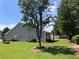 Well-maintained backyard with expansive lawn, mature trees, and newly painted siding at 964 Village View Cir, Loganville, GA 30052