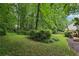 Lush backyard featuring mature trees, a grassy lawn, and a charming deck, creating a serene outdoor space at 1369 Willowbrook Sw Dr, Marietta, GA 30064