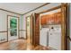 Laundry room with wooden cabinets, washer and dryer, and access to the back yard at 1369 Willowbrook Sw Dr, Marietta, GA 30064