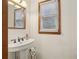 Bathroom features white pedestal sink, framed mirror, and window at 1369 Willowbrook Sw Dr, Marietta, GA 30064