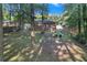 View of a large backyard area with a brick home, mature trees, and lush green grass at 2773 Fairlane Dr, Atlanta, GA 30354