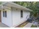 Exterior view of home with clean white siding, lush trees, and steps to the side entrance at 2773 Fairlane Dr, Atlanta, GA 30354