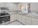Bright kitchen featuring white cabinets, granite countertops, stainless steel appliances, and mosaic backsplash at 2773 Fairlane Dr, Atlanta, GA 30354
