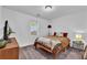 Cozy carpeted bedroom with a full sized bed, bedside tables, and decorative lamps at 2912 Palm Dr, East Point, GA 30344