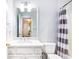 Bright white bathroom with a single vanity, a mirror, and a shower/tub with curtain at 404 Summerchase Way, Woodstock, GA 30189