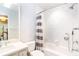 This white bathroom has a large mirror and a tub/shower with tile surround at 404 Summerchase Way, Woodstock, GA 30189
