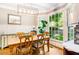 Dining room with wood table set beneath modern light fixture, adjacent to a large window at 404 Summerchase Way, Woodstock, GA 30189
