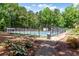 Well-maintained tennis court nestled among trees, offering recreational opportunities for residents at 404 Summerchase Way, Woodstock, GA 30189