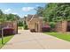 Impressive gated driveway leading to a distinguished brick home with manicured landscaping at 5172 Roswell Rd, Marietta, GA 30062