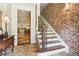 Inviting foyer with stone floors and an adjacent staircase with an ornate wrought iron banister at 5172 Roswell Rd, Marietta, GA 30062