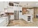 Modern kitchen with white cabinets, stainless steel appliances, and stone floors at 5172 Roswell Rd, Marietta, GA 30062