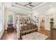 Bright main bedroom featuring hardwood floors, a ceiling fan, and decorative wrought iron bed at 5172 Roswell Rd, Marietta, GA 30062