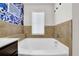 Elegant bathroom features a soaking tub with tile surround and decorative blue wallpaper at 2333 White Oak Se Bnd, Smyrna, GA 30080