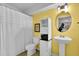 Yellow bathroom features a combination tub and shower with a vanity and medicine cabinet at 2333 White Oak Se Bnd, Smyrna, GA 30080