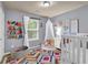 Bright bedroom featuring a playful design, cozy play area, and a crib, creating a warm, inviting space at 2333 White Oak Se Bnd, Smyrna, GA 30080