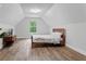 Large bedroom with hardwood flooring, sloped ceilings and a window with a view of the trees at 3455 Henderson Dr, Cumming, GA 30041