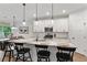 Charming kitchen featuring white cabinetry, a marble countertop island with pendant lighting, and stainless steel appliances at 3455 Henderson Dr, Cumming, GA 30041