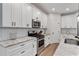 Modern kitchen featuring white cabinets, stainless steel appliances, and a herringbone backsplash at 3455 Henderson Dr, Cumming, GA 30041